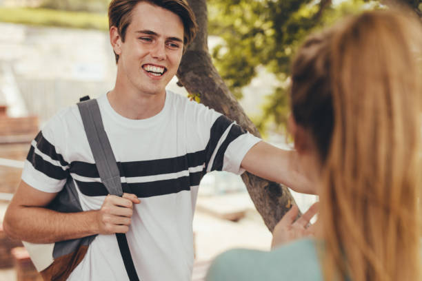 istock Smiling boy talking with a girl at high school campus after the class 1322498364