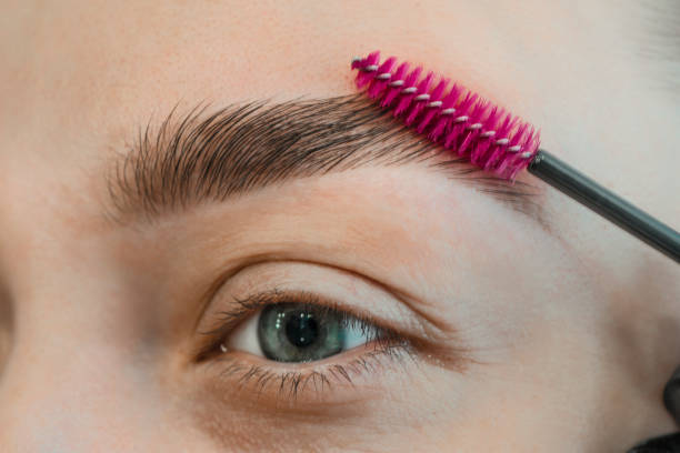 combing, plucking eyebrows close-up. close up of woman doing her make up, preparing brows using brush tool brushing eyebrows. - make up cosmetics women make up brush imagens e fotografias de stock