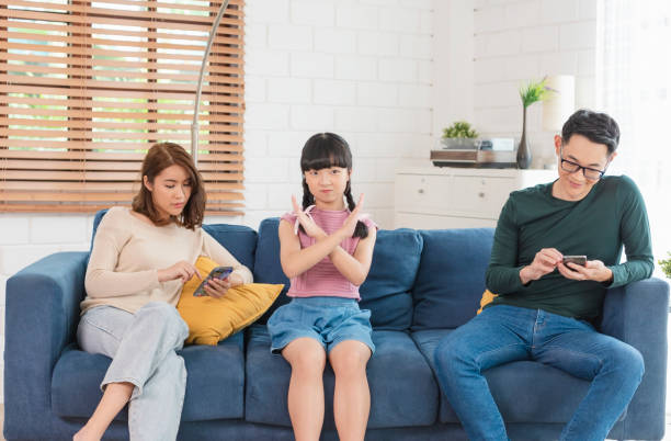 istock Asian parent using tablet and mobile phones at home. addicted to devices, gadgets dependence overuse. 1322500427