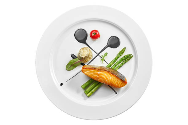 Grilled salmon steak with asparagus and balsamic sauce in a white plate. Isolated on white background. View from above