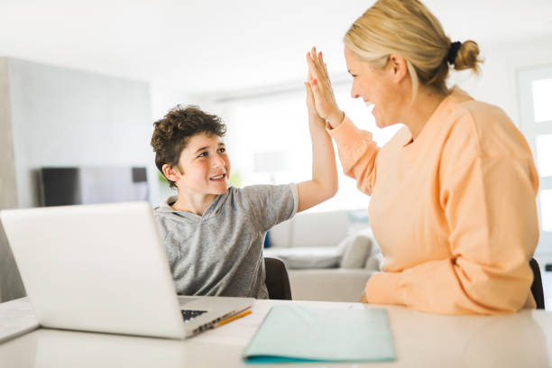 istock Mom helping kid with homework at home 1322500632