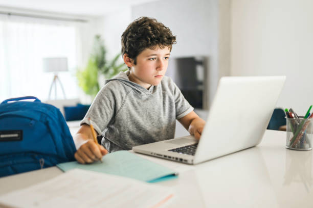 istock Pretty teen boy enjoys learning and doing some homework 1322501503