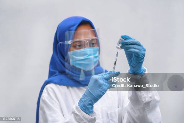 Indonesian Healthcare Worker Filling A Syringe With The Vaccine Stock Photo - Download Image Now