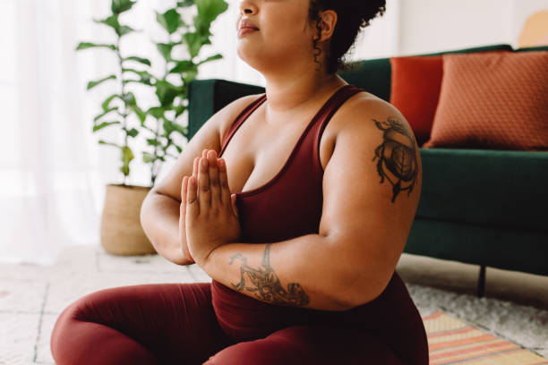 istock Plus size woman practicing yoga meditation at home 1322505398