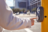 Shot of a businessman pressing a button at a crosswalk in the city