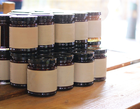 Blank labelled jars of jams/jellies at a market stall/trade fair.