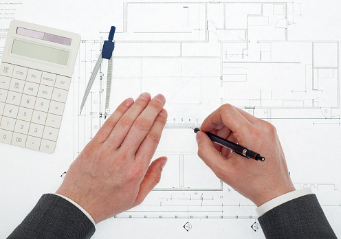 Architect drawing on blueprints