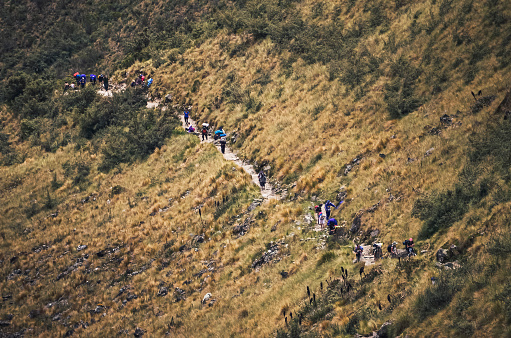 Unrecognizable backpackers hiking the inca trail from aerial view, on they way to Machu Picchu archaeological site from the Inca's ancient civilization in Peru. South America
