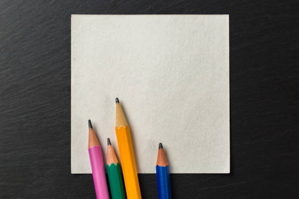istock Colored pencils on paper for notes on a gray background. Copy Space 1322511556