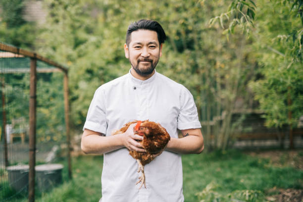istock Smiling Japanese man holding a chicken. 1322511707