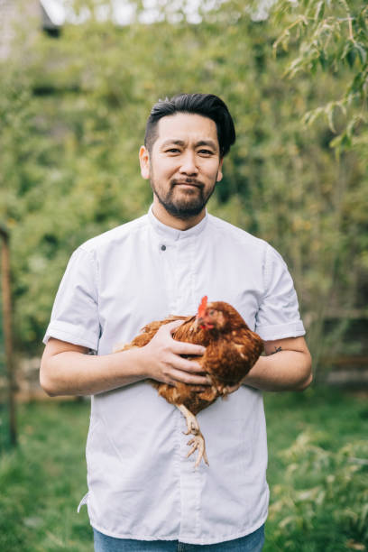 istock Smiling Japanese man holding a chicken. 1322511717