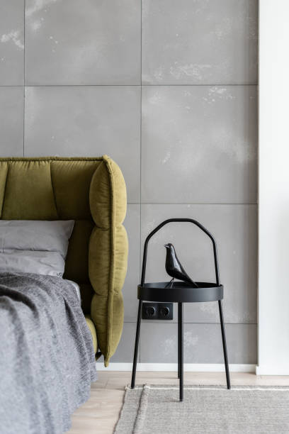Stylish metal bedside table with artificial black bird