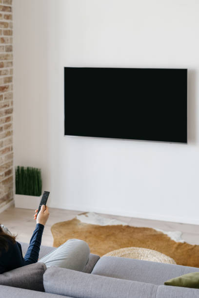 istock Woman watching TV while relaxing at home 1322512334