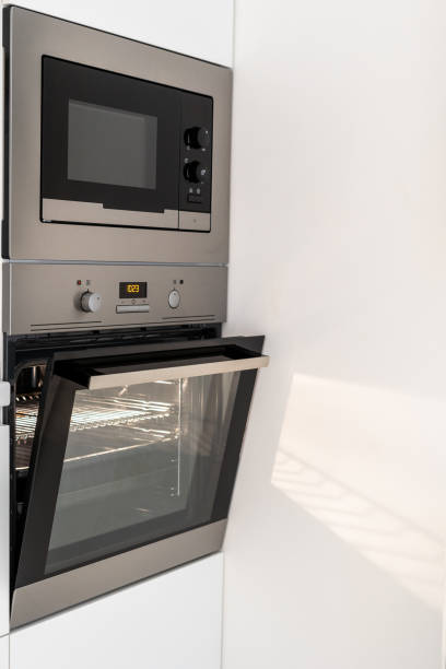 istock Modern steel microwave and opened oven in kitchen 1322512360
