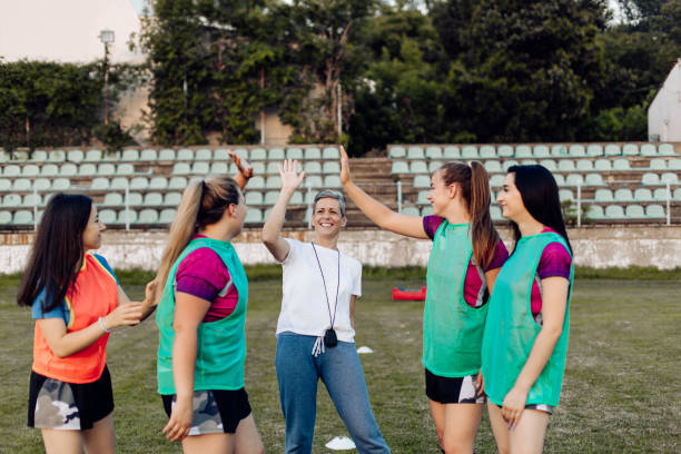 istock Female rugby team celebrating success with coach 1322512671