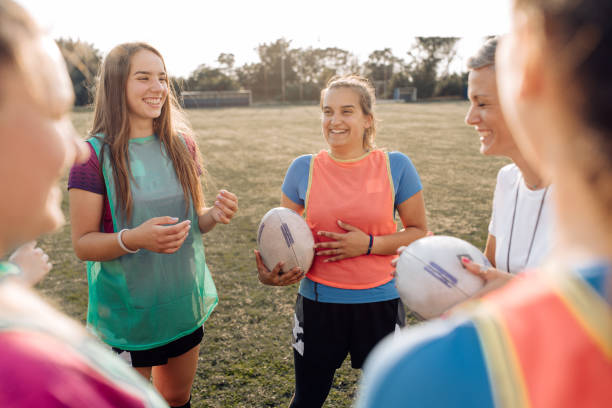 istock Girls rugby team gathering with their coach on training 1322512737