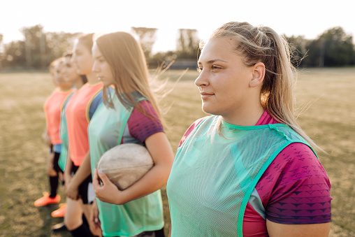 Girls from the female rugby team standing in line and preparing for a rugby game.