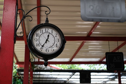 old retro clock hanging on a column in the bus station corridor