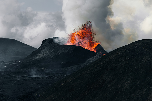 Scenic view of dark volcanic landscape with fresh melting lava and the new volcano at Geldingadalur, Iceland