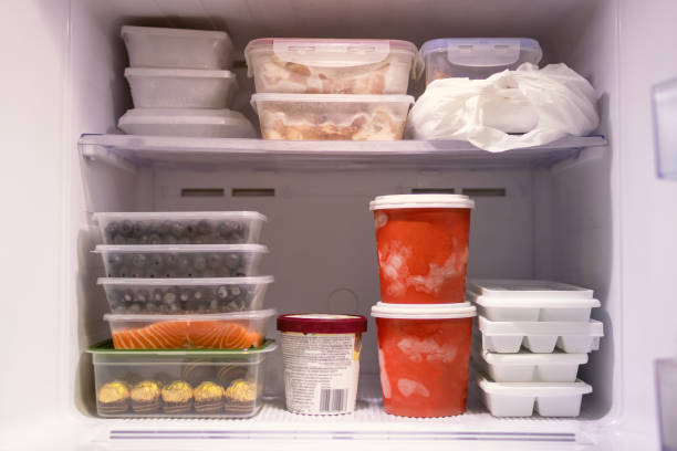 voll mit tiefkühlkost im kühlschrank. fleisch, fisch, obst, schokolade, eis und eimer behälter eis aromen in gefrierregalen. vorräte an essen und machen sie sich bereit für den sommer. - gefrierschrank stock-fotos und bilder
