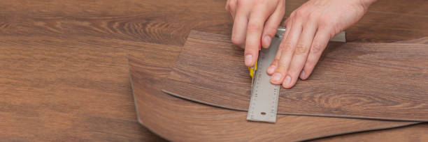 istock DIY vinyl flooring. Easy installation and cutting with a knife, Master cuts vinyl plank before installation, brown heated floor. Copy space 1322521134