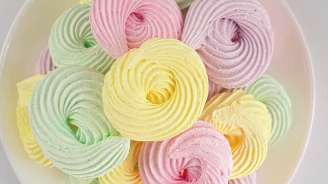 Close-up delicious meringue cookies pastel colors rotating video.