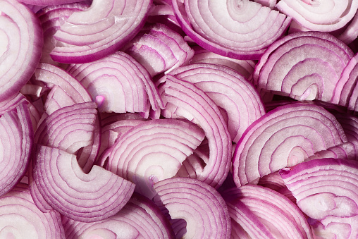 Sliced purple onions. Spanish red onion slices. Horizontal slicing. Background