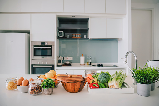 domestic kitchen with fruits and vegetables on kitchen counter