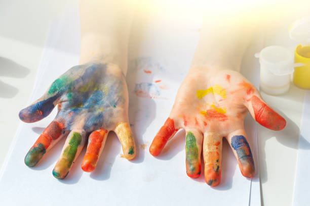 istock Palms painted on childrens hands with multi-colored paints. Childs hobby creativity and art. Children Protection Day. Happy childhood. 1322524791