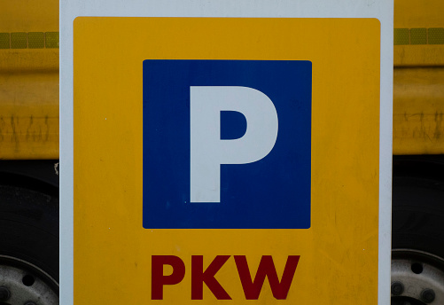 a blue parking lot road sign with a white P letter