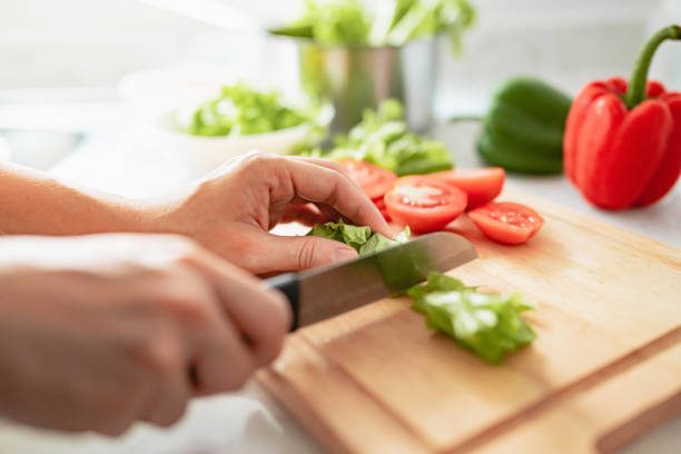 istock Human hands cooking in kitchen. Woman slicing vegetable. 1322526395