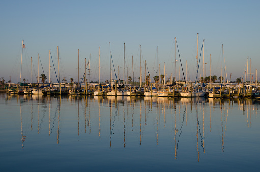 The sailboats and their reflections provide a scene of relaxation in the soft light that follows sunrise. The air is still and the day promises adventure.