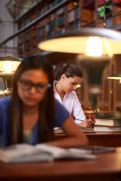 istock Young women reading in library 1322530483