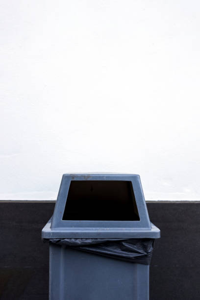 istock closeup gray trash bin on white cement background 1322530555