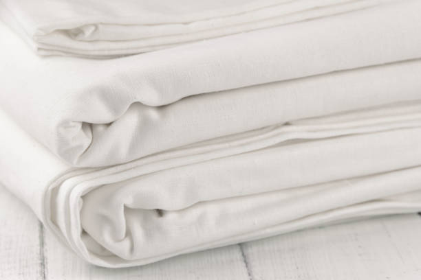 istock Stack of clean bed linen on white wooden table 1322531689