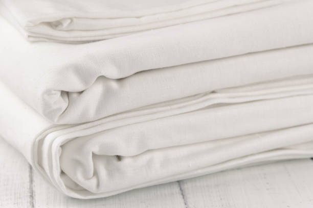 Stack of clean bed linen on white wooden table stock photo