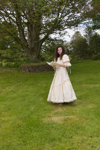 istock Victorian lady reading a book in her garden 1322532119