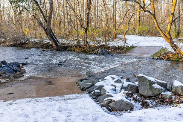 Northern Virginia Fairfax County's Sugarland Run Stream Valley Trail with covered path by water and snow in winter with nobody at sunset