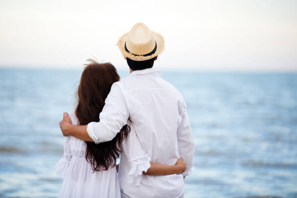 istock Happy Romantic Couples lover holding hands together walking on the beach 1322534332