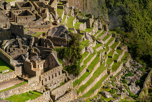 Wide view of happy young Peruvian woman enjoying the view while hiking in Sacred City of Machu Picchu, Peru