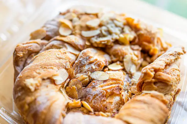 Photo of Closeup of danish almond kringle nut strudel pastry open package with macro texture on baked dessert golden crust and filling