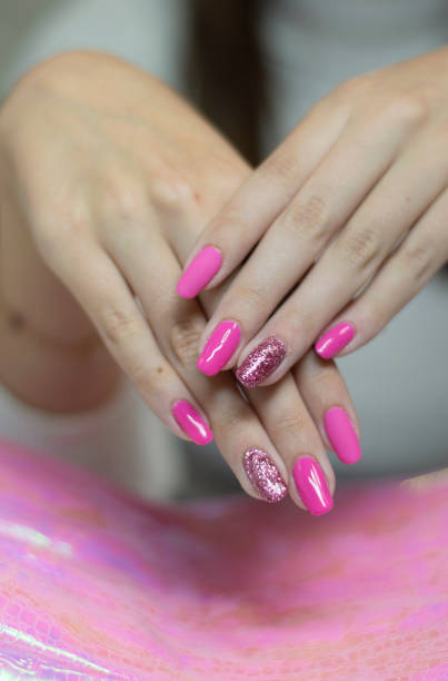 istock Hands up close to those manicured with bright pink manicure on the nails. Selective focus 1322535314