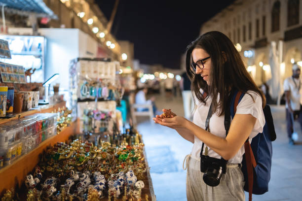 Woman shopping at street market in Doha Young beautiful caucasian woman at Souq Waqif market. Exploring Doha with camera. night market stock pictures, royalty-free photos & images
