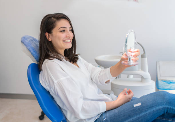 歯科医院で笑顔で鏡を見る若い女性 - dentists chair dental equipment dentist office dental drill ストックフォトと画像