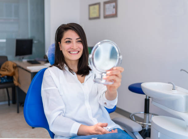 istock Young Woman Looking At Mirror With Smile In Dentist’s Office 1322538897