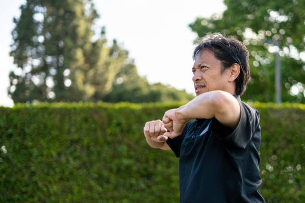 istock Mature Filipino man stretching before playing tennis 1322543878