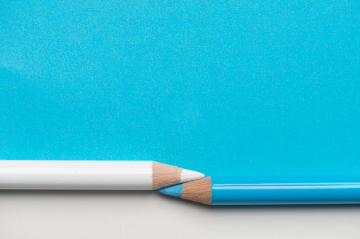 Two pencil on the two colored background. Blue and white.