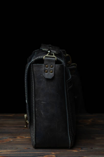 istock Dark leather messenger bag with rivet straps. 1322545147