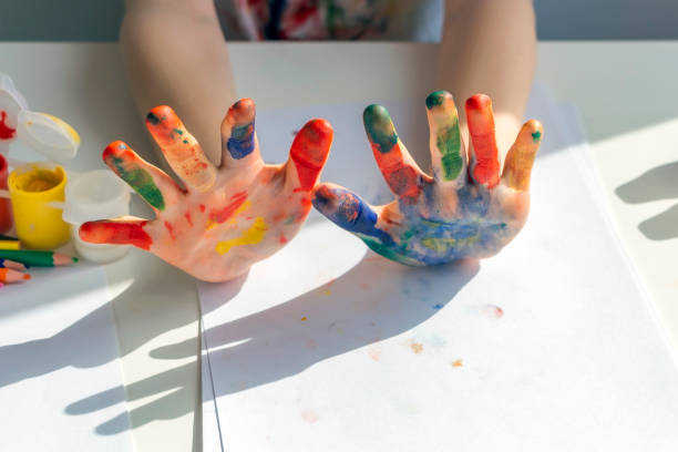 istock Palms painted on childrens hands with multi-colored paints. Childs hobby creativity and art. Children Protection Day. Happy childhood. 1322546274