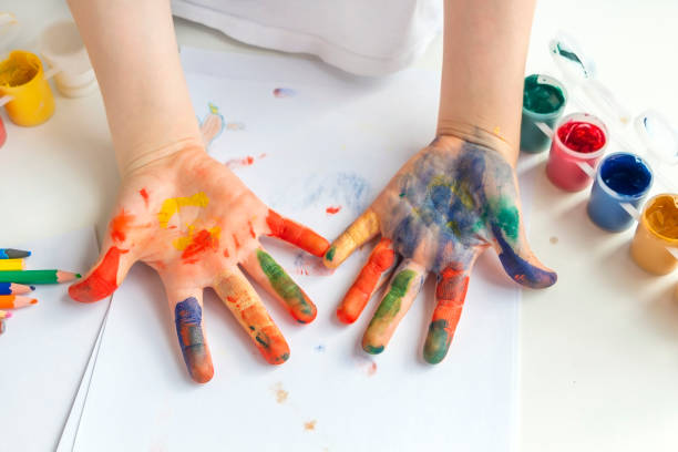 istock Palms painted on childrens hands with multi-colored paints. Childs hobby creativity and art. Children Protection Day. Happy childhood. 1322546275